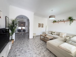 A modern living room with a sofa, coffee table, and dining area. - Townhouse in a quiet neighborhood (El Chaparral)