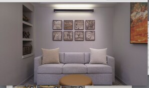 Un soggiorno dai toni neutri con un divano grigio, due cuscini, un poggiapiedi rotondo e un lampadario a parete.