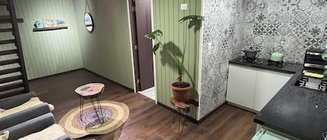 Una sala de estar con comedor, cocina y escalera.