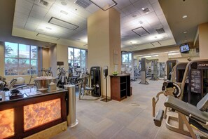 A gym with various exercise machines, a reception desk, and large windows. - MGM Signature-27-705 F1 Track & Strip View Balcony (Las Vegas)