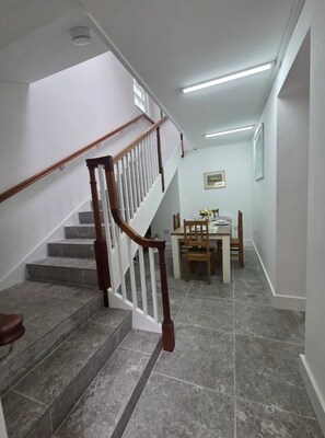 A staircase with wooden handrails leading to a dining area with a table and chairs. - St Mary's Cottage One
Entire 2 bedroom cottage - a home from home (Dover)