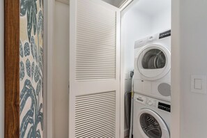 A laundry room with stacked washing machines and dryers. - Luxury 1BR Residence at One GT · Rooftop Pool & Views (George Town)