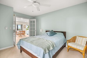 Une chambre à coucher avec un lit, une chaise et un ventilateur de plafond.