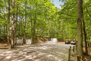 A campground with a paved parking area, portable cabins, and a forested backdrop. - Loggers Lookout Condo at The Homestead (Glen Arbor)