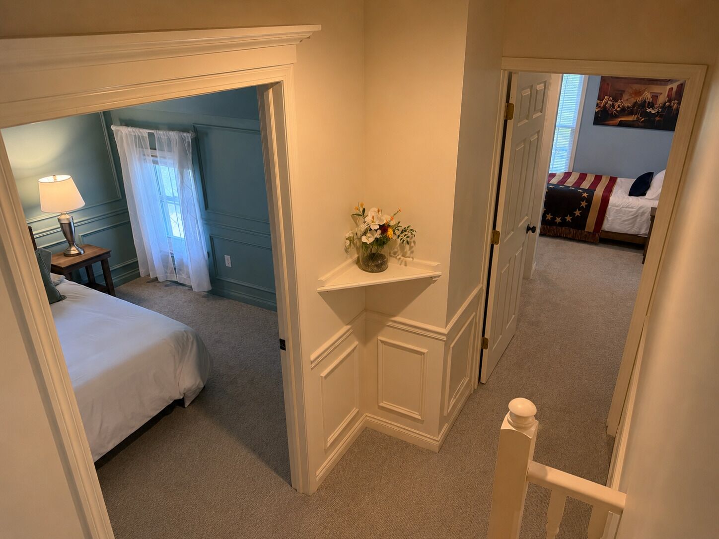 Un dormitorio con cama, mesita de noche, lámpara y ventana con cortinas.
