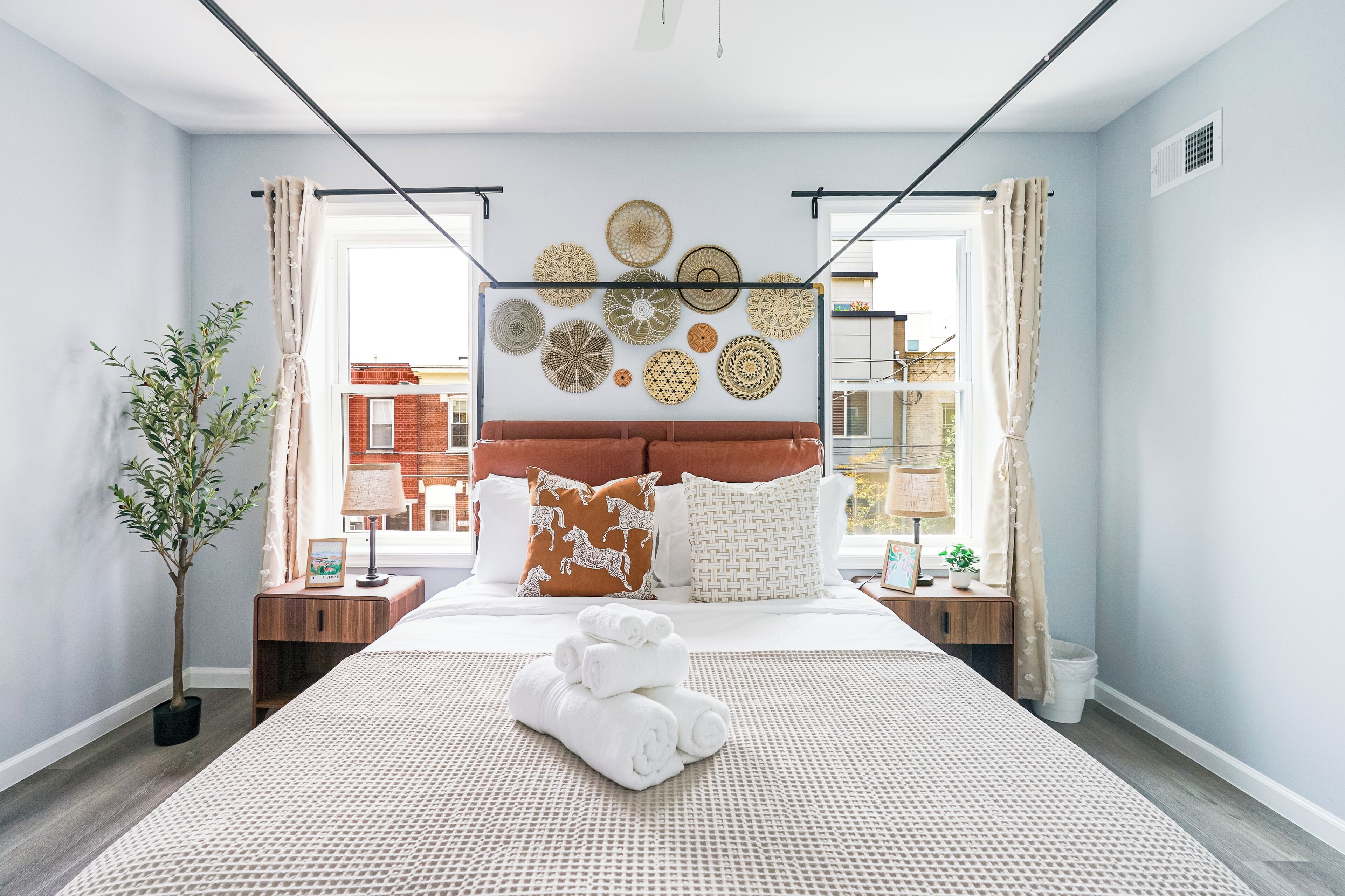 Ein modernes Schlafzimmer mit einem großen Bett, Wanddekoration und Blick auf die Stadt.