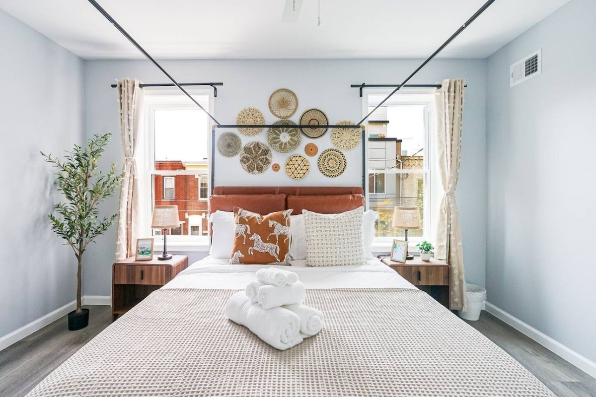 Habitación de hotel con cama, una obra de arte en la pared, planta en maceta y vistas al exterior.