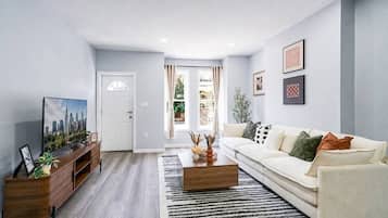 A modern living room with a sofa, coffee table, and entertainment unit.