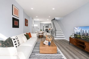 A modern living room with a sofa, coffee table, and artwork on the wall.