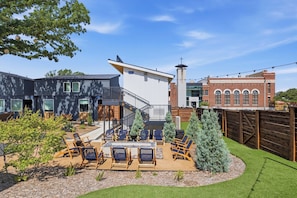 Een modern woonhuis met een terras, zitplaatsen buiten en een keurig onderhouden tuin.