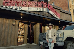 Un edificio con un letrero que dice 'CATTLEMEN'S CATTLE HOUSE STEAK HOUSE'.