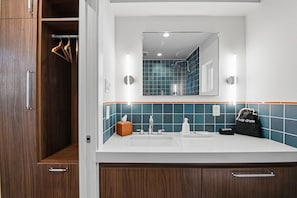 A bathroom with a white sink, mirror, and blue-tiled walls. - King casita with parking, minutes to downtown (Fort Worth)