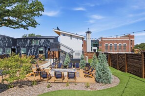 Una propiedad residencial moderna con patio, mobiliario exterior y un jardín bien cuidado.