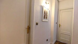 A hallway with white walls, a framed picture, and a door with a gold handle. - Casa Kate La Zenia (Orihuela)