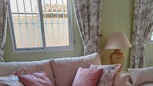 A living room with a sofa, a glass coffee table, and a vase with flowers. - Casa Kate La Zenia (Orihuela)