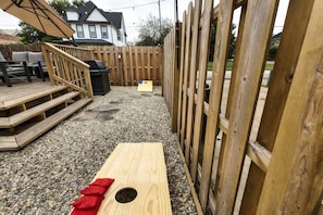 A backyard with a wooden deck, a barbecue grill, and a wooden play structure. - The Social House - 7BR, Hot Tub & Pool Table (Indianapolis)