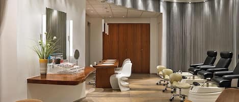 A modern reception area with a wooden desk, white chairs, and a seating area with leather chairs.