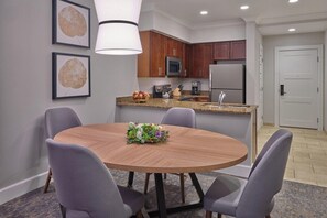 A modern kitchen with wooden cabinets, stainless steel appliances, and a granite countertop.
