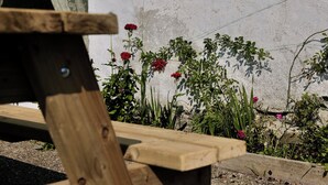 A wooden bench with a concrete wall in the background. - Charming Irish Cottage Offering Peace, Comfort and Stunning Lough View (Londonderry)