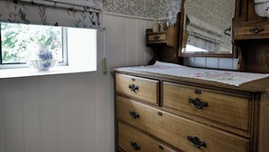 A wooden dresser with multiple drawers and a mirror above it. - Charming Irish Cottage Offering Peace, Comfort and Stunning Lough View (Londonderry)