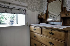 A wooden dresser with multiple drawers and a mirror above it.