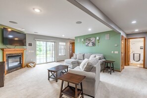 A living room with a fireplace, a flat-screen TV, a grey sofa, and a wooden coffee table.