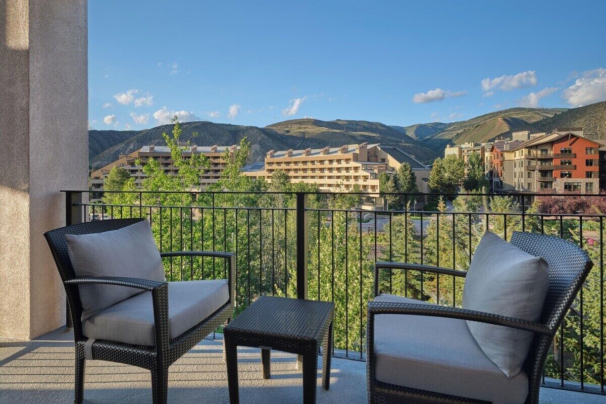 Un balcone con mobili in vimini e vista su un paesaggio montuoso.