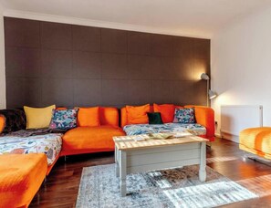 Ein modernes Wohnzimmer mit einem Ecksofa, einem Couchtisch und einer Heizung.