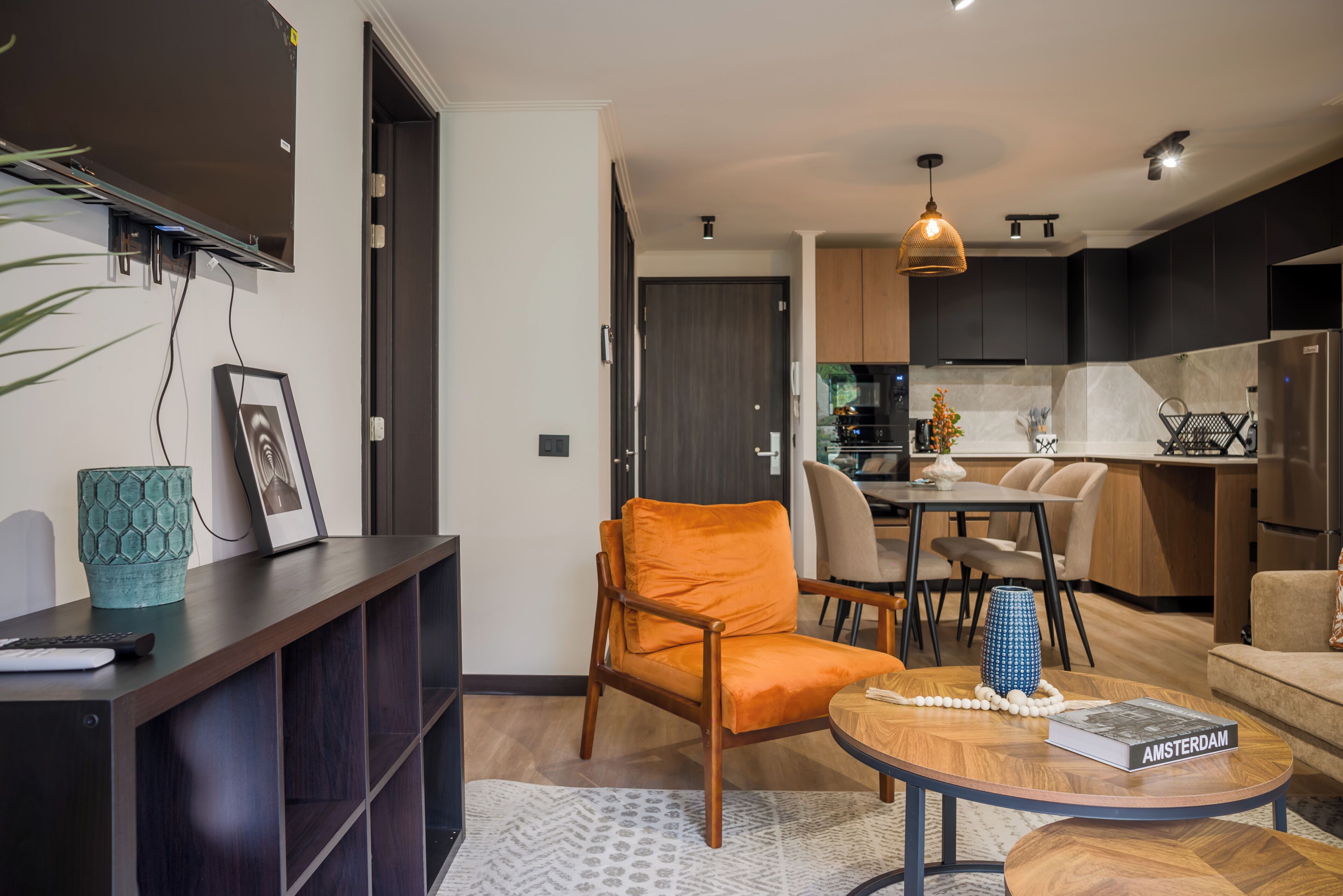 Uma sala de estar moderna com um sofá, uma mesa de centro e um espaço de jantar com cadeiras.