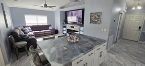 Un salon moderne avec un canapé, une table basse et un téléviseur.