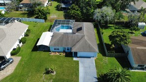A residential area with a house featuring a swimming pool, a garage, and a well-maintained lawn.