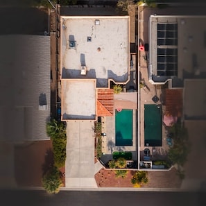 Eine Dachterrasse mit Schwimmbad, überdachter Terrasse und einer kleinen Gartenanlage.