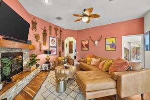 A living room with a fireplace, a sofa set, a coffee table, and a ceiling fan. - Welcome to the Hotel California in the Historic La Quinta Cove (La Quinta)