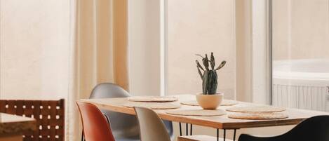 A dining area with a wooden table, chairs, and a hanging plant.