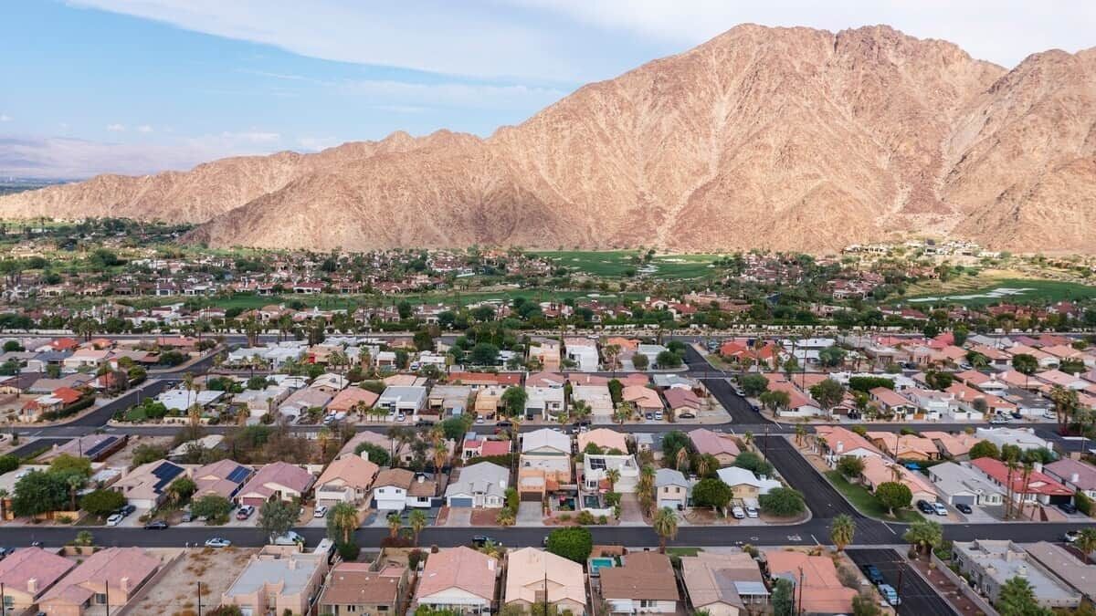A residential area with houses and a mountain backdrop.