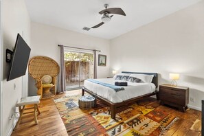 A bedroom with a bed, bedside table, chair, and a television mounted on the wall. - Welcome to the Hotel California in the Historic La Quinta Cove (La Quinta)