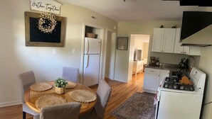 Un'area pranzo con un tavolo rotondo, sedie e una ghirlanda decorativa appesa al muro.