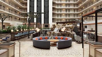 A multi-level hotel lobby with a central seating area, a waterfall feature, and multiple balconies.