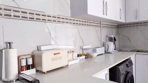 A kitchen with a bread maker, coffee maker, and a dishwasher. - Saob Property- South A (Germiston)