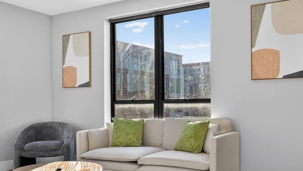 A modern living room with a sofa, a round coffee table, and artwork on the walls.