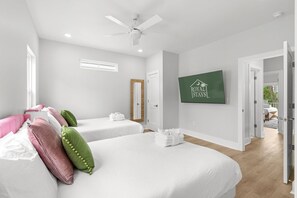A hotel room with two beds, a ceiling fan, a mounted TV, and a view of the outside. - Pink Palmetto 2.5 Blocks to Beach Pets (Myrtle Beach)