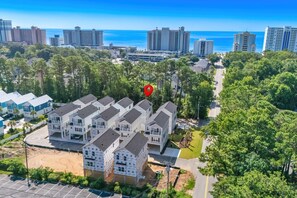 A residential area with multiple-story houses, a clear view of the ocean, and a red location marker. - Pink Palmetto 2.5 Blocks to Beach Pets (Myrtle Beach)
