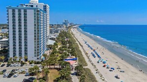 A coastal hotel with a beach view, parking, and a high-rise building. - Pink Palmetto 2.5 Blocks to Beach Pets (Myrtle Beach)