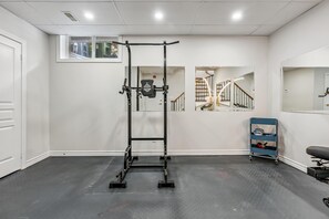 A home gym with a pull-up bar, weight rack, and a blue cart with weights. - Luxurious townhome ideal for families, business travelers, and long stays. (Toronto)