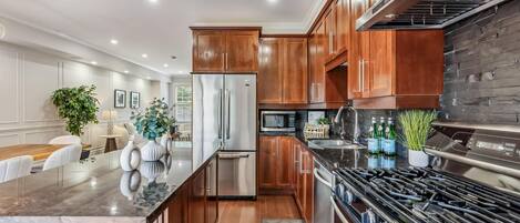 Una cocina moderna con armarios de madera, electrodomésticos de acero inoxidable y encimera de granito.