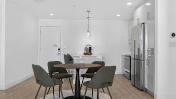 A modern kitchen with a central island, white cabinets, and stainless steel appliances.