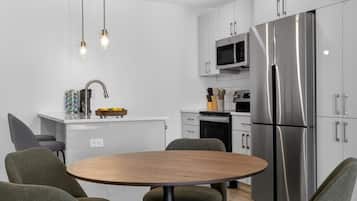 Dining area beside the full kitchen with seating for group meals.