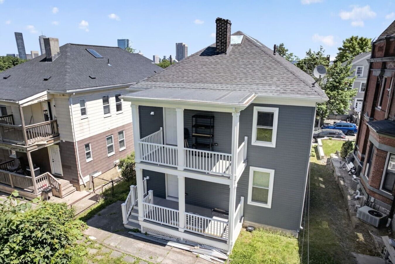 A two-story residential building with a balcony, a chimney, and a satellite dish.