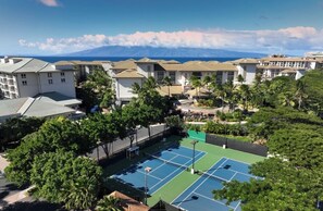 A residential area with multiple buildings, a tennis court, and a view of a mountain range. - ALOHA!! GRAND Ocean view 1-BdRm studio VILLA  on the gorgeous Kaanapail Beach (Lahaina)