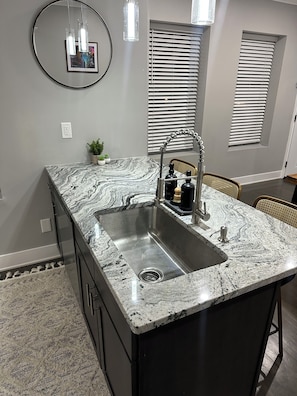 A kitchen with a granite countertop, stainless steel sink, and modern fixtures. - Spacious 2 unit Gordon SQ building! 2 bed 2 bath! 2 kitchens! 2 living rooms! (Cleveland)